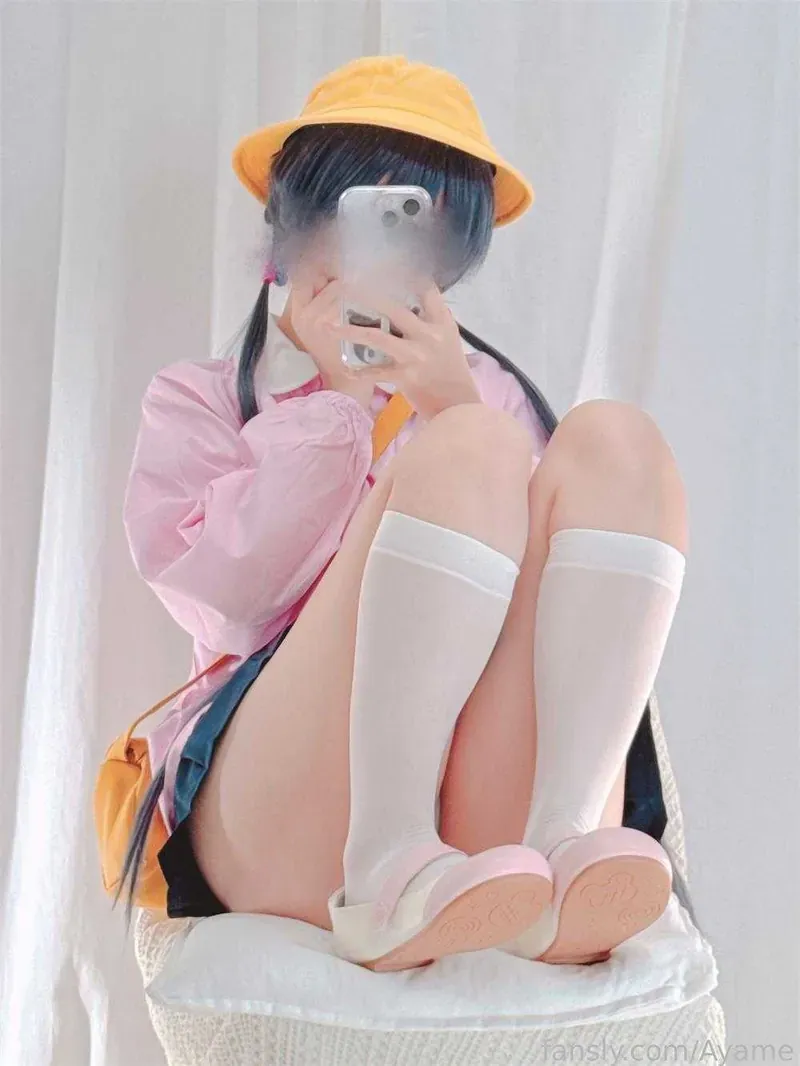 平台线索与Cosplay写真风格更新 戴帽搭配粉色服装的坐姿造型照片