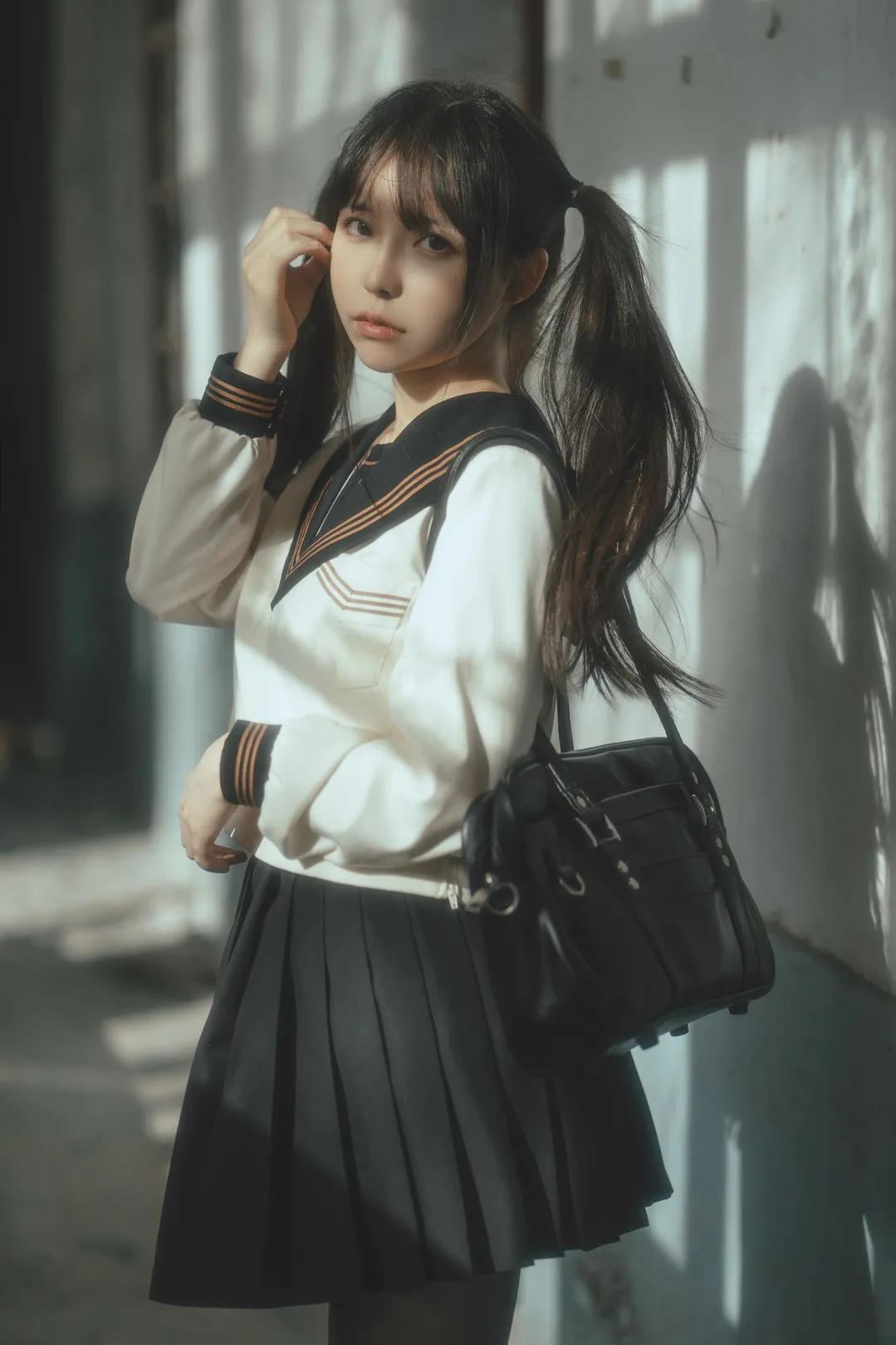 社媒平台与写真风格更新线索 穿校园风服装站立于室内光影环境中的照片