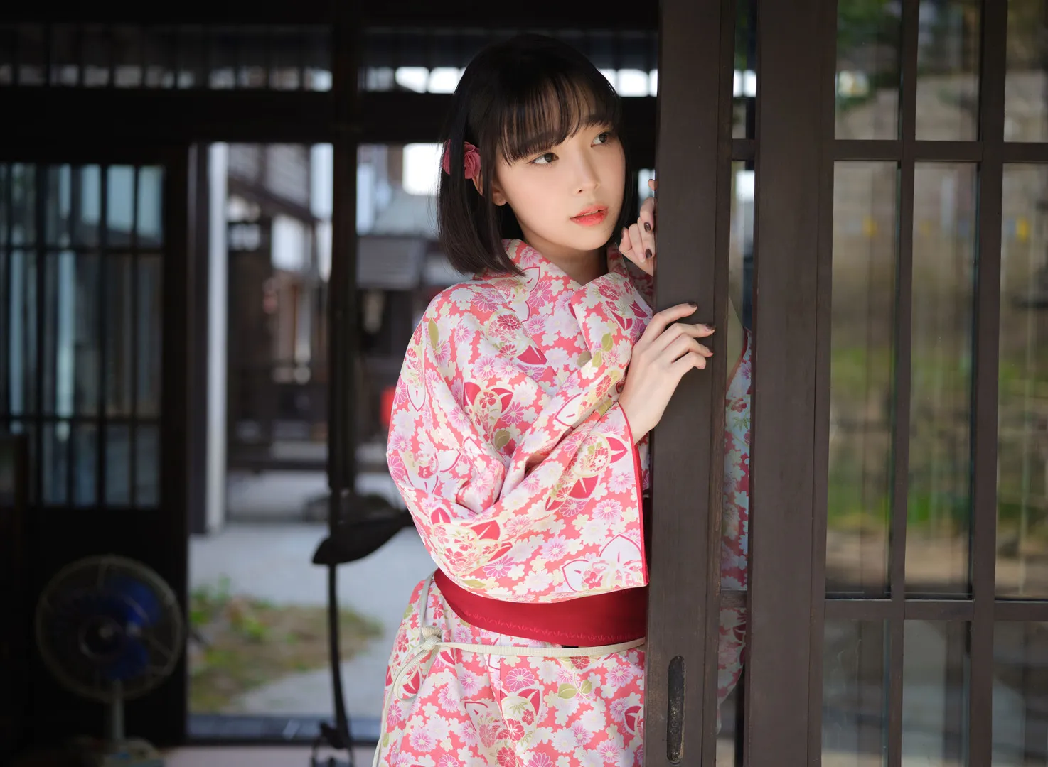 Instagram公开线索、写真风格与更新范围 短发齐刘海人物穿粉白花纹日式服饰站在深色木质门框旁