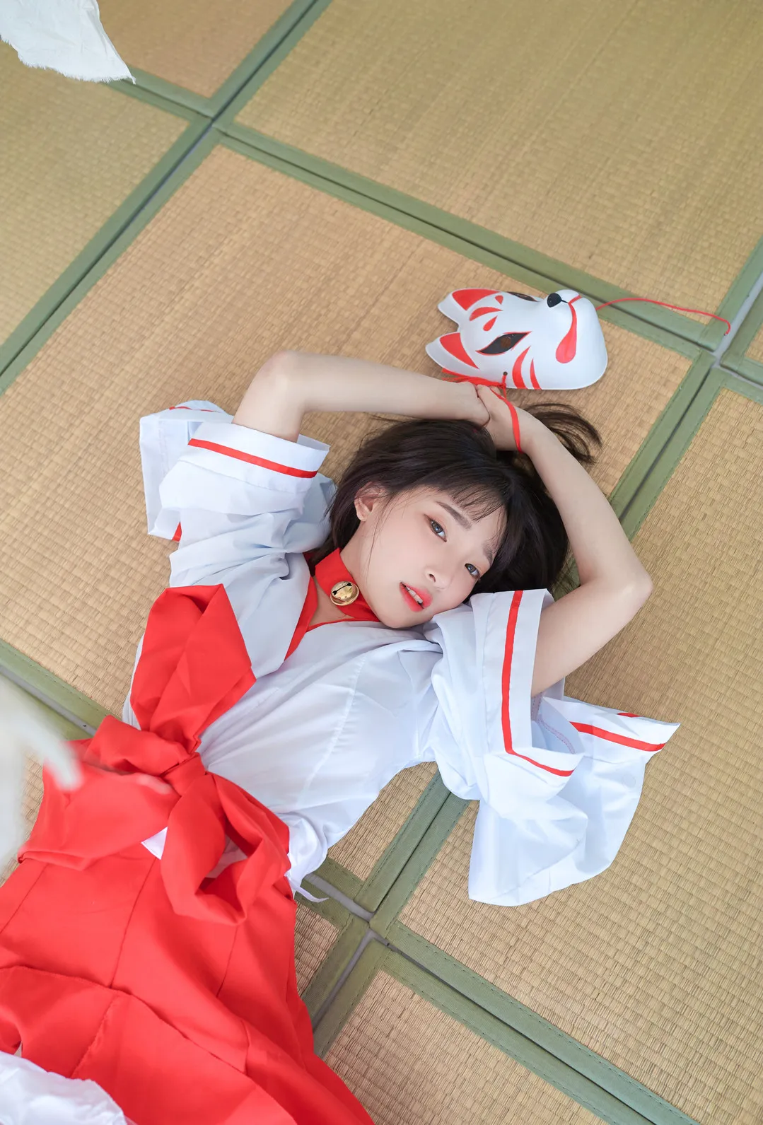 Instagram公开线索、写真风格与更新范围 人物穿红白角色服躺在榻榻米上，头侧放有红白狐狸面具