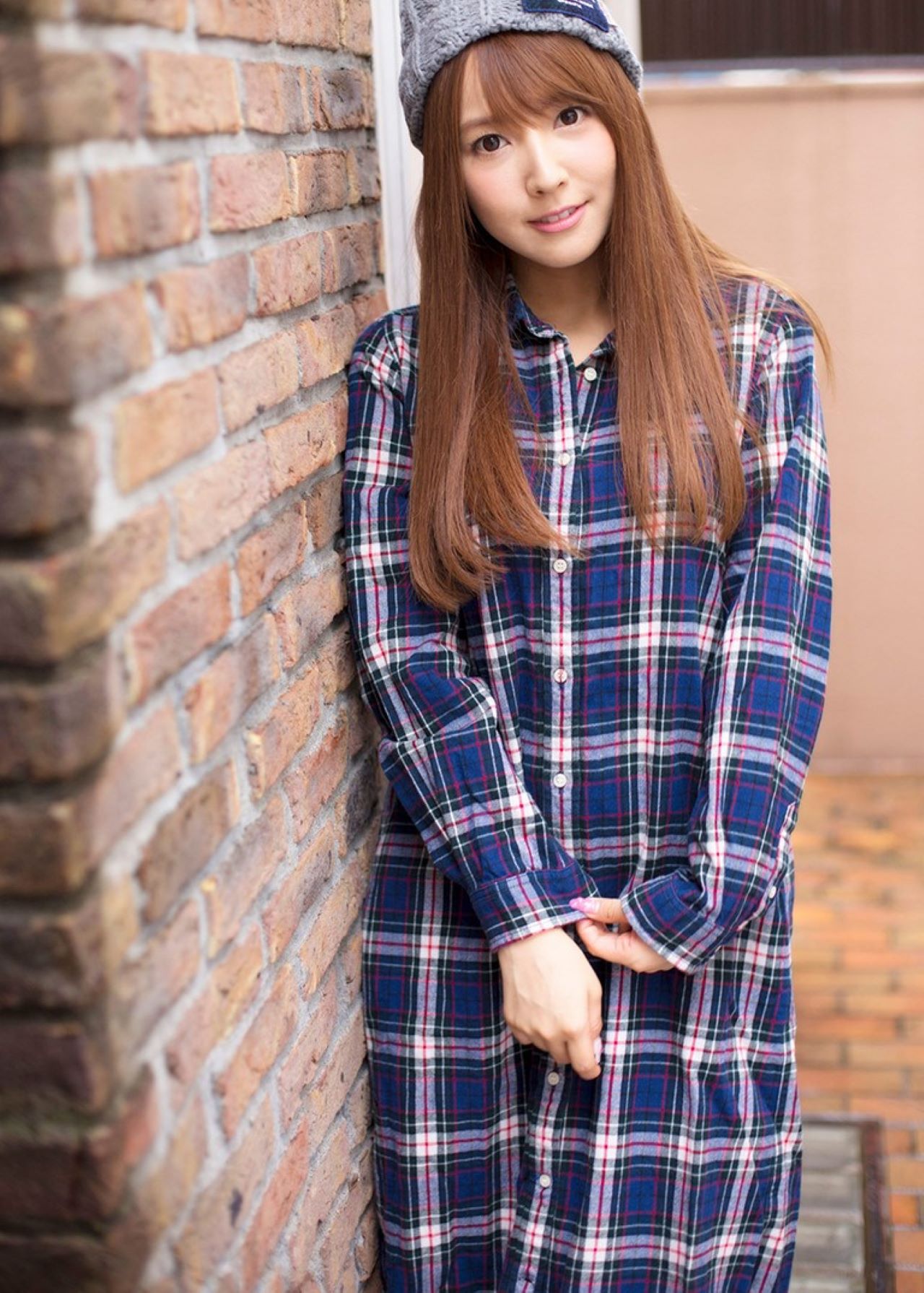公开平台线索与写真 格纹长款服装照片，砖墙背景与暖色环境