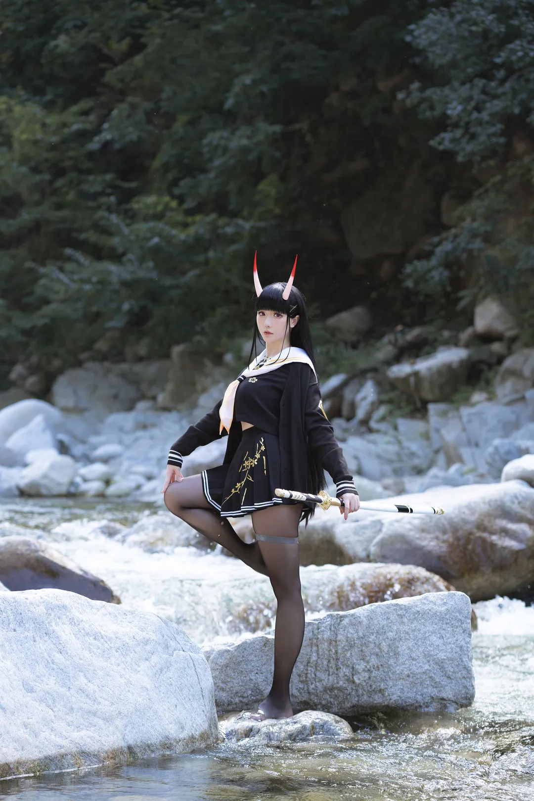 社媒平台与Cosplay风格更新线索整理 黑色制服角色Cosplay造型，河边岩石环境中的户外写真