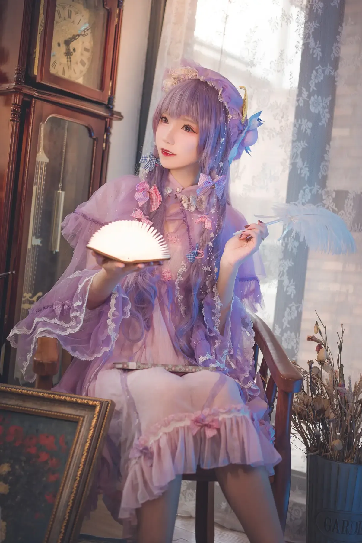 然理理身着紫色洛丽塔风格服装，手持团扇，坐在椅子上