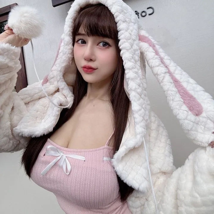 Instagram与YouTube社媒写真风格更新线索 穿粉色服装搭配兔耳帽的室内自拍照片