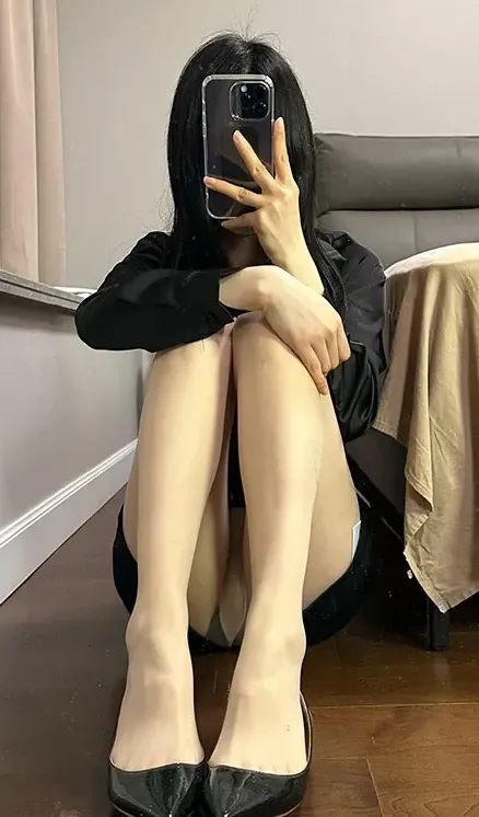黑底碎花挂脖开衩旗袍短裙配透薄连裤袜深色床边木地板屈膝侧卧自拍