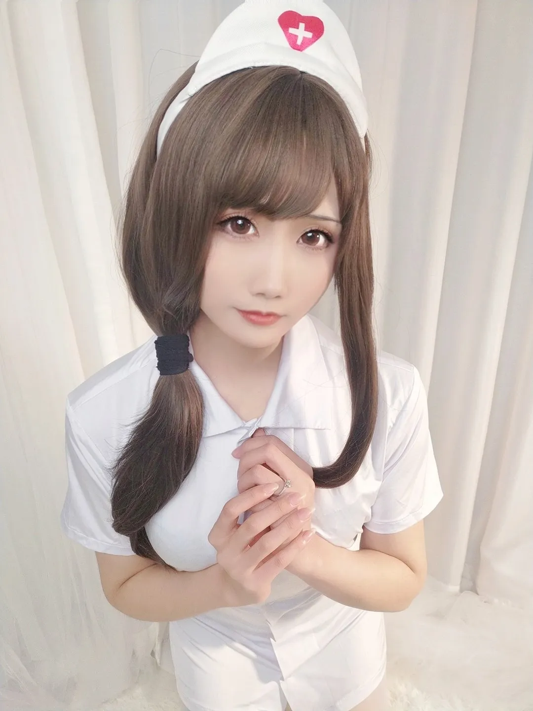 纯白爱心护士帽配短袖翻领护士服双手合十半身近景