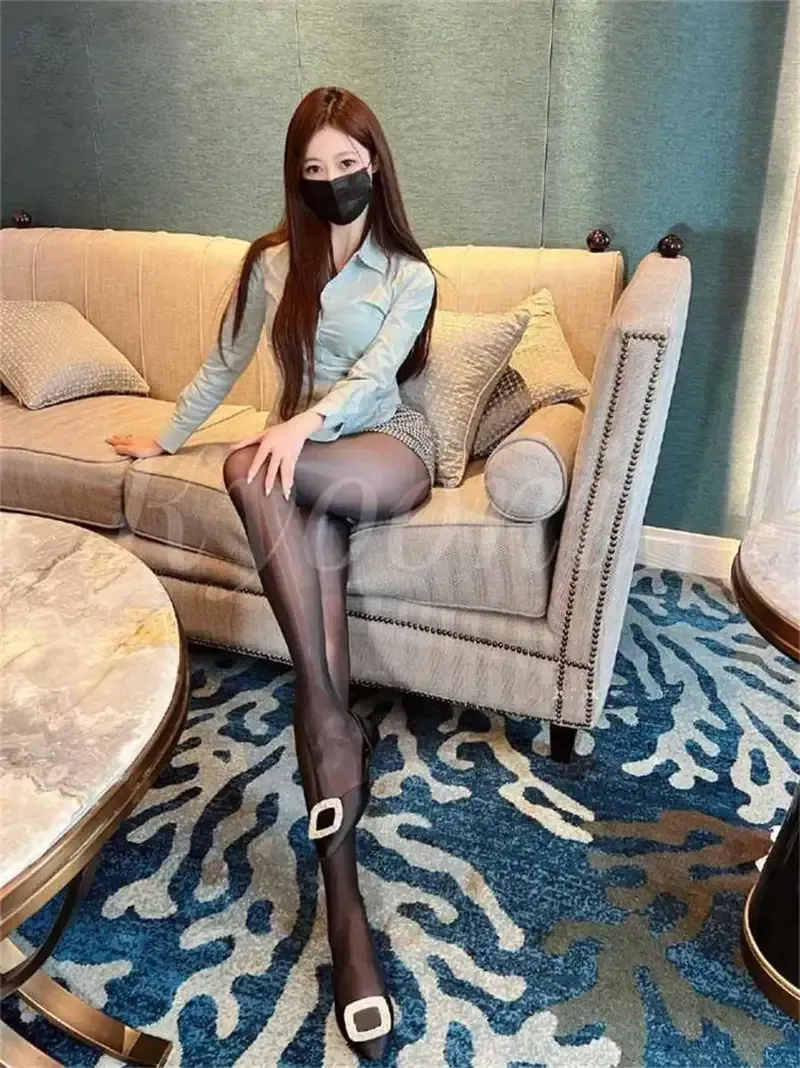 浅青色修身长袖衬衫配短裙透薄黑丝袜方扣高跟鞋米色沙发端坐姿态