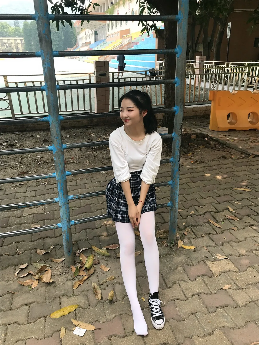 湖畔攀爬架旁纯白长袖T恤蓝黑格纹百褶裙白色长袜黑色低帮帆布鞋坐姿