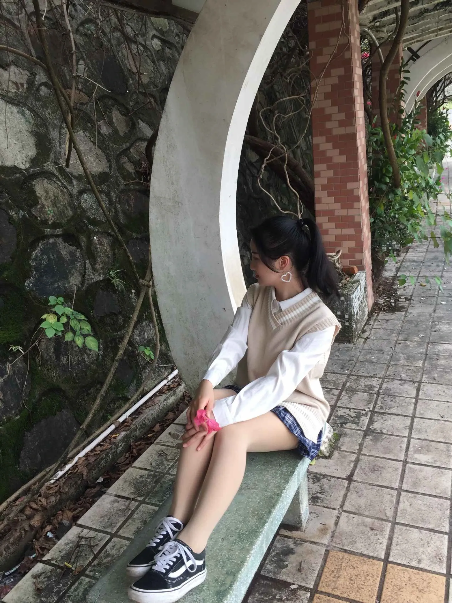 米白针织马甲白衬衫搭配黑白配色低帮帆布鞋园林拱门长椅侧坐